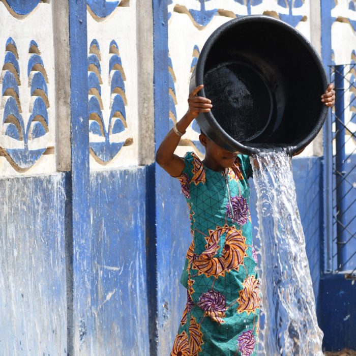 a girl pouring water out of a container
