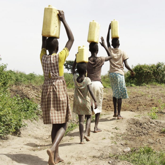 kids carrying container of water